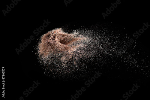 Gold sand explosion isolated on black background. Abstract sand cloud.