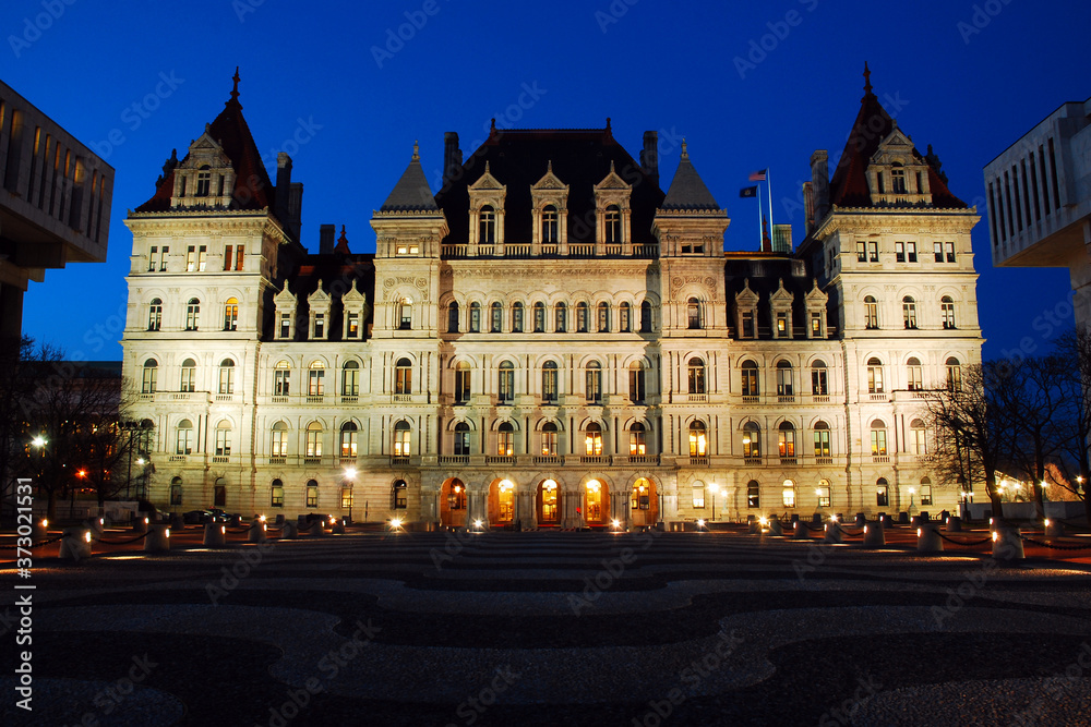The New York State Capitol Building is illuminated at dusk