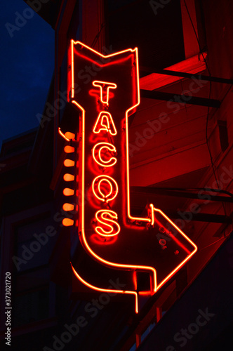 Photography A neon sign advertising tacos glows in the San Francisco night