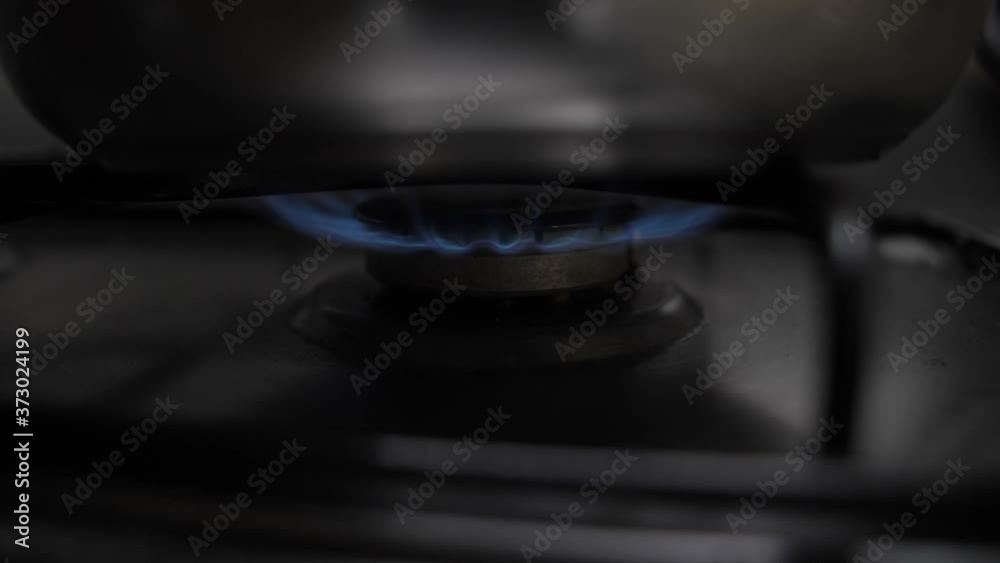taking cooking pot over gas stove nozzle taking cooking pot over gas stove nozzle