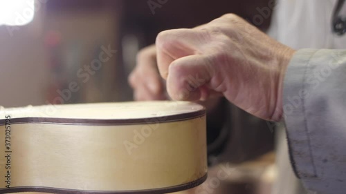 Craftsman artisan file wood with sharp knife to make guitar 