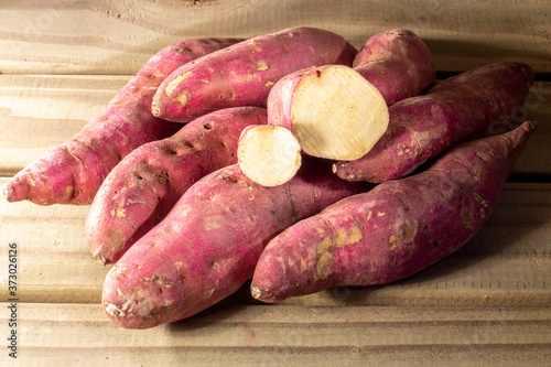 Red sweet potato pile on wooden background in Brazil