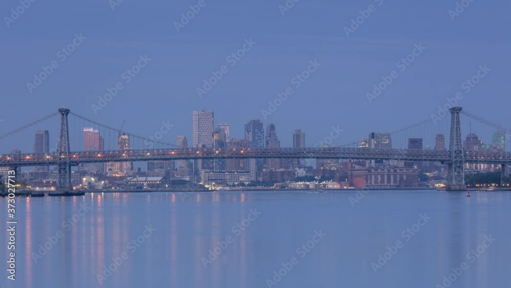 View on Williamsburg bridge from East River in the night to day time lapse View on Williamsburg bridge from East River in the night to day time lapse