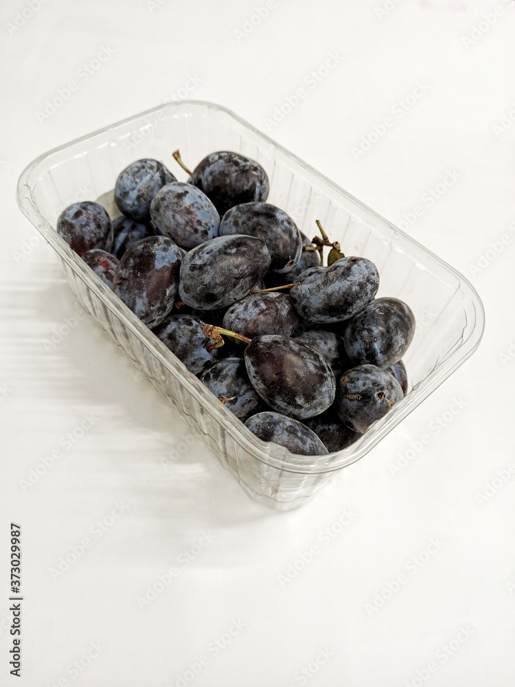 Plums in a package isolated on a white background