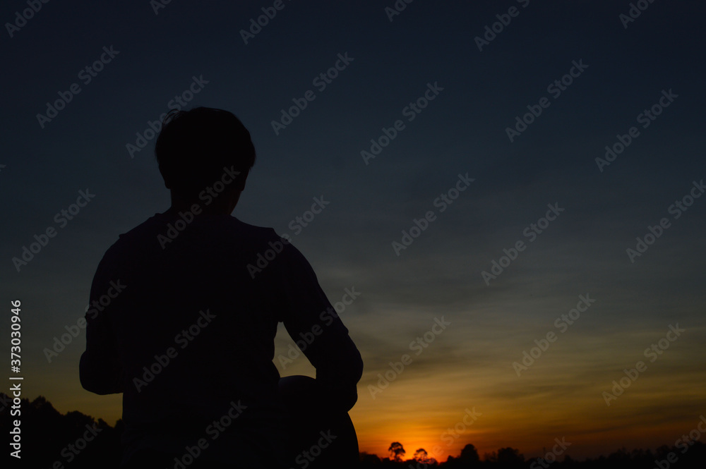 A man with a guitar strumming and looking at the sunset in the evening A man with a guitar strumming and looking at the sunset in the evening