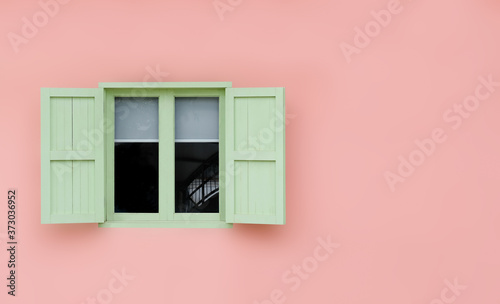 Vintage opened green mint shutters and wooden windows isolated on pink background with copy space and clipping path.