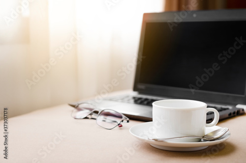 Working from home with laptop glasses pen and coffee cup hot in the morning. Workspace background composition with space for text. Enjoy love relax time during working at home with copy space.