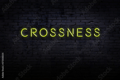 Neon sign. Word crossness against brick wall. Night view photo