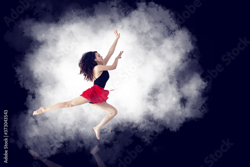 A long-legged girl jumping in front of a minimalist, graceful background