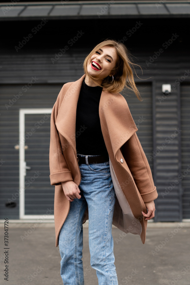 Happy woman wearing in coat walking on the street Happy woman wearing in coat walking on the street