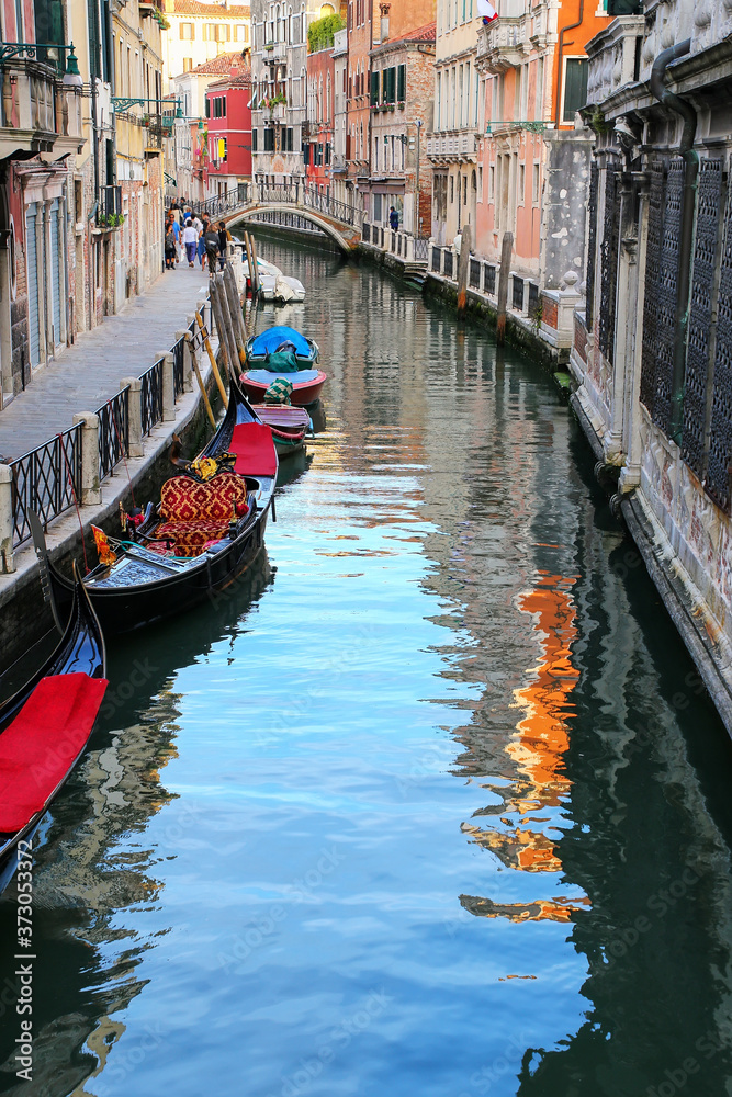 Narrow canal lined with gondolas in Venice, Italy