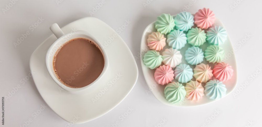 Multicolored meringues and a cup of coffee on a white background. isolated. panorama, panoramic - obrazy, fototapety, plakaty 