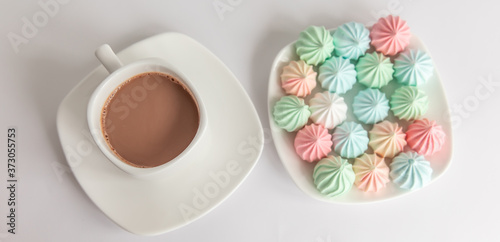 Multicolored meringues and a cup of coffee on a white background. isolated. panorama, panoramic