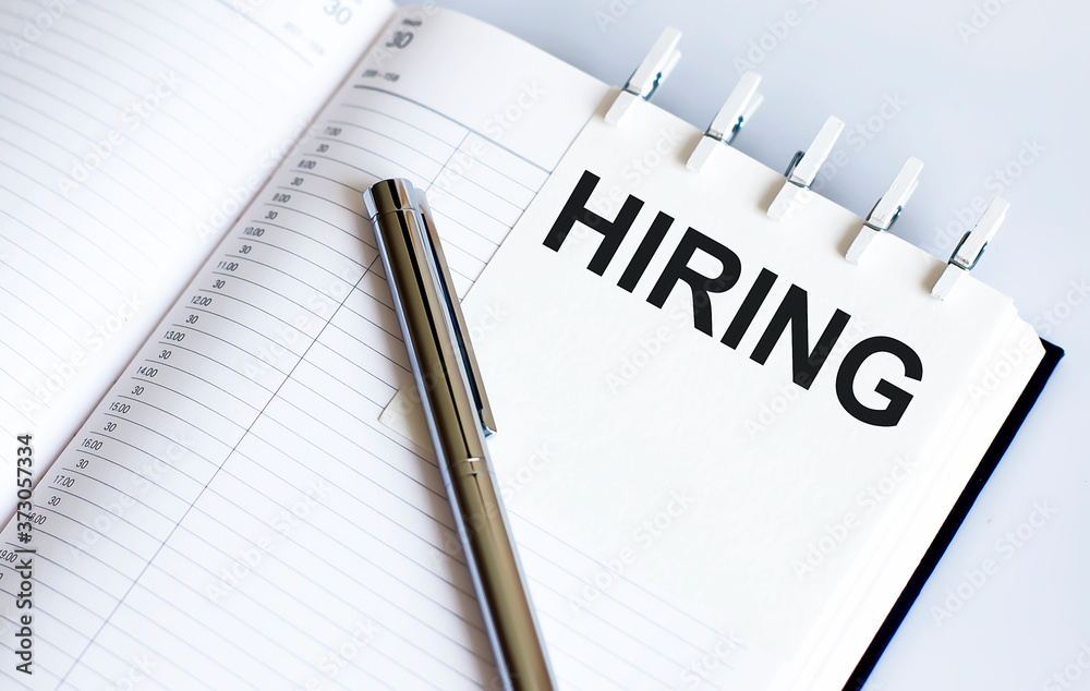 text HIRIRNG on the short note texture background with pen