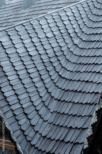 shingles on the roof. Wooden roof, shingled roof. Wooden tile. Roof of complex construction with dormer windows