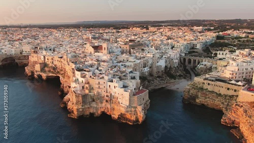 polignano a mare town aerial view drone flying orbit over sea at sunrise apulia italy