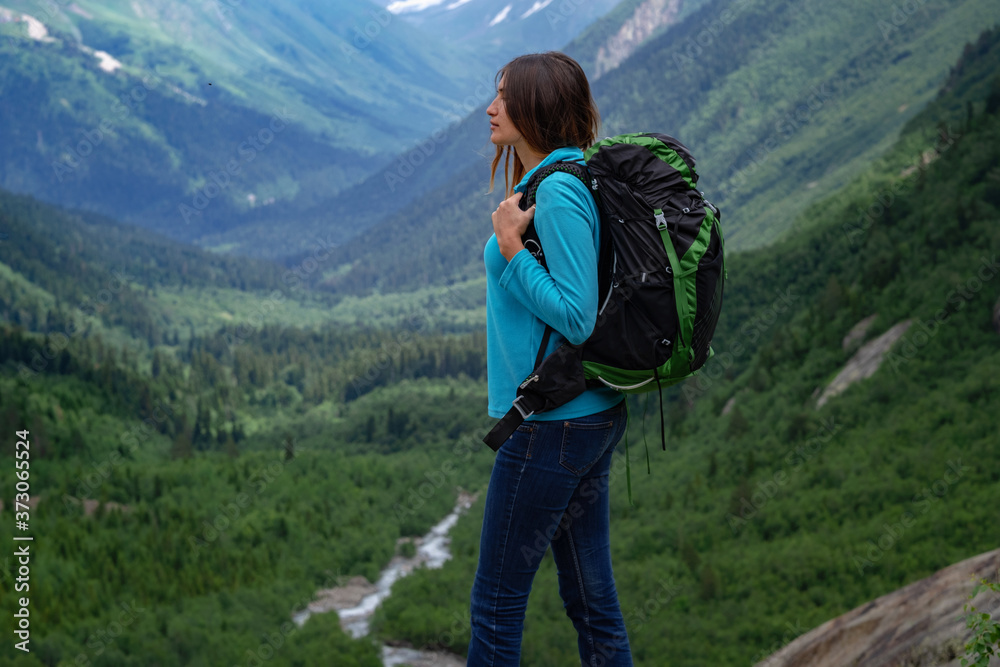 Backpacker on top of a mountain enjoying valley view Backpacker on top of a mountain enjoying valley view