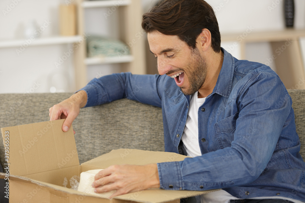 happy man opening parcel box at home happy man opening parcel box at home