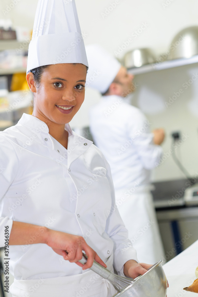 female young chef mixing something in the bowl female young chef mixing something in the bowl