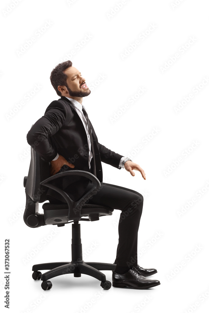 Professional man at work holding a painful lower back and sitting on a chair Professional man at work holding a painful lower back and sitting on a chair