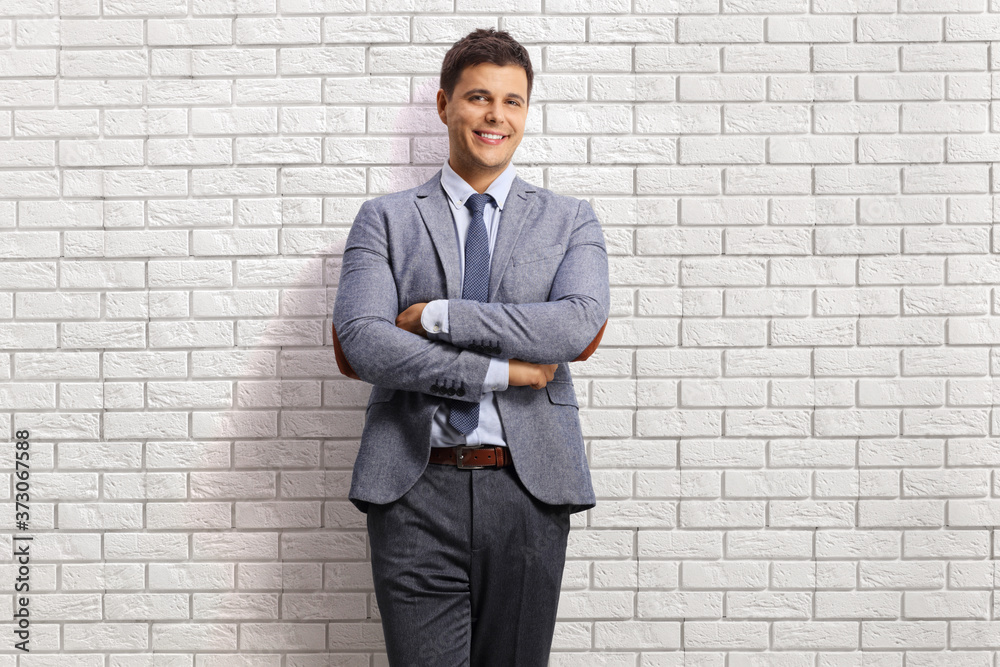 Professional young man posing on a white brick wall Professional young man posing on a white brick wall