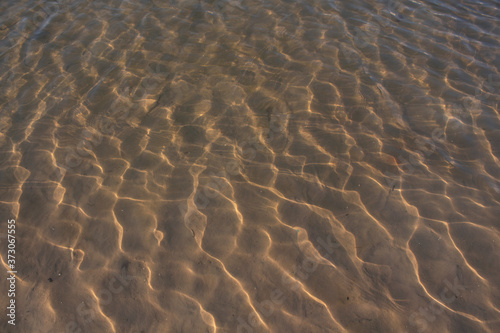 The texture of the sandy bottom of the lake.