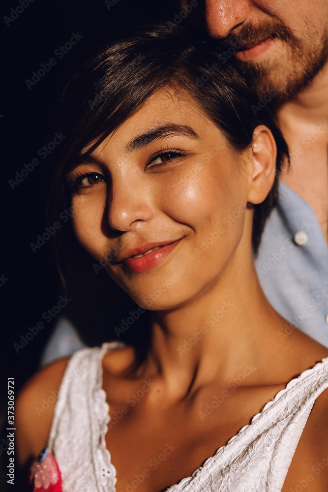 Portrait of pretty woman in white top with man behind Portrait of pretty woman in white top with man behind