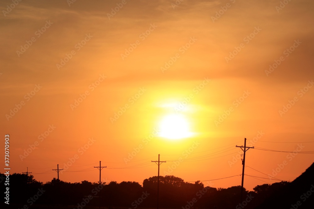 power lines at sunset in Kansas out in the country.