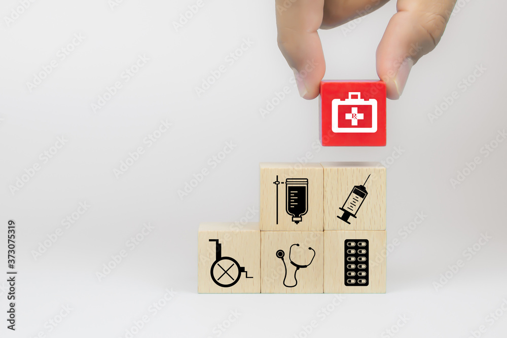 Hand choose medical tool bag icon on cube wooden toy blocks stack in with other hospital medical symbols concepts of illness treatment and health safety insurance. Hand choose medical tool bag icon on cube wooden toy blocks stack in with other hospital medical symbols concepts of illness treatment and health safety insurance.