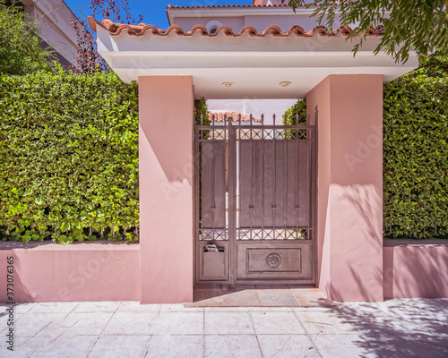 elegant house entrance metallic door by the sidewalk © Dimitrios