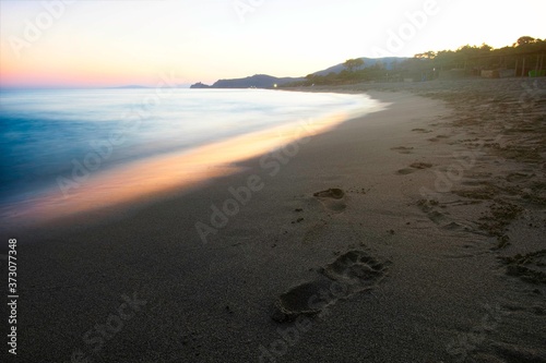 Beautiful mediterranean coast in sunset with fingerprints in sand.