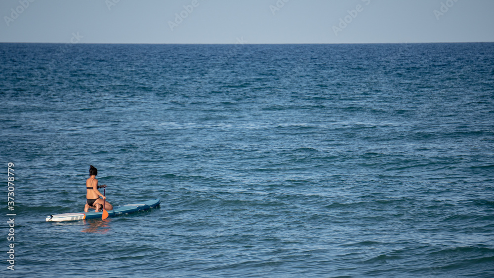 Mujer surfeando en el océano en un día soleado