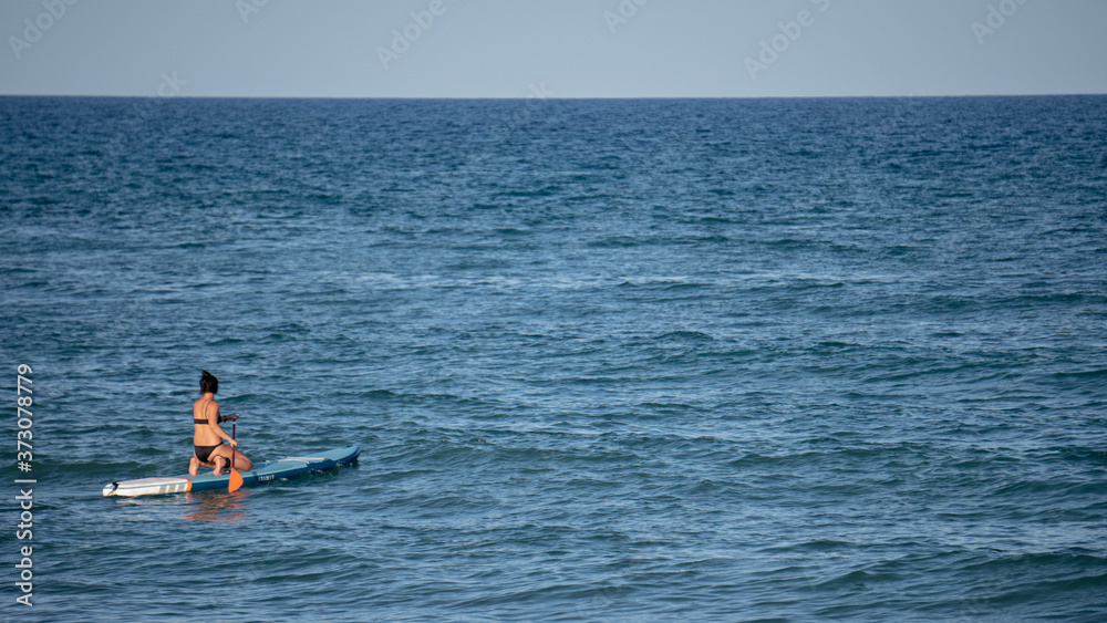 Mujer surfeando en el océano en un día soleado Mujer surfeando en el océano en un día soleado