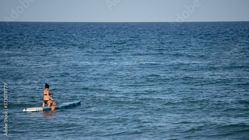 Mujer surfeando en el océano en un día soleado © Miquel