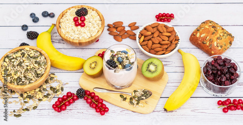 Fruits and Breakfast with Whole grains and nuts, yogurt mix with Cherry , banana, avocado in the wooden table. Breakfast for Health and Diet concept © Bussarin