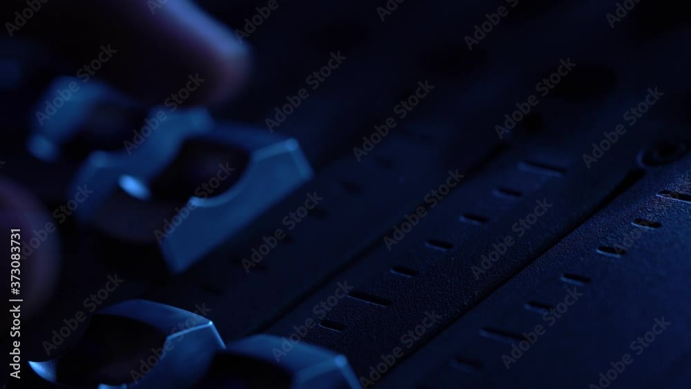 Man working on professional digital audio channel mixer in studio. Electronics for amplifier and balance of sound in show. Soundboard knobs. sound engineer presses the keys. Closeup Man working on professional digital audio channel mixer in studio. Electronics for amplifier and balance of sound in show. Soundboard knobs. sound engineer presses the keys. Closeup