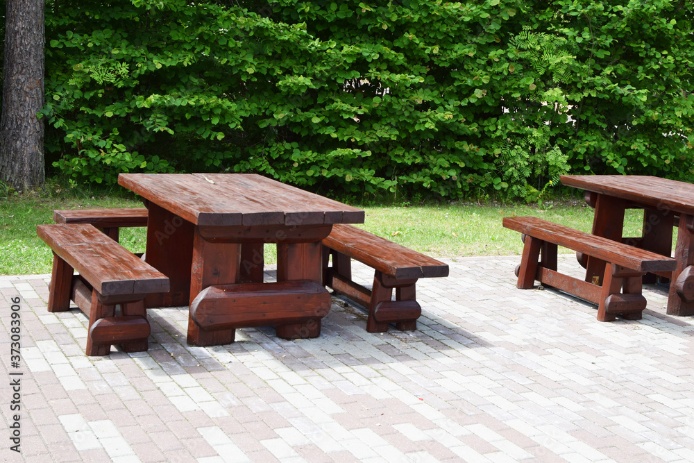 Empty chairs and tables in outdoor restaurant or public nature park in summer time.
Empty chairs and tables in outdoor restaurant or public nature park in summer time.