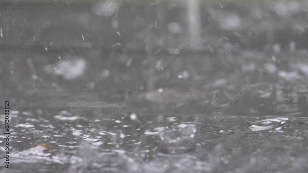 Slow motion speed close up scene on raindrop fall against and bounce on floor, flood from rainstrom in bad rainy day, natural pattern of pouring rain bumping on ground, grainy texture of water Slow motion speed close up scene on raindrop fall against and bounce on floor, flood from rainstrom in bad rainy day, natural pattern of pouring rain bumping on ground, grainy texture of water