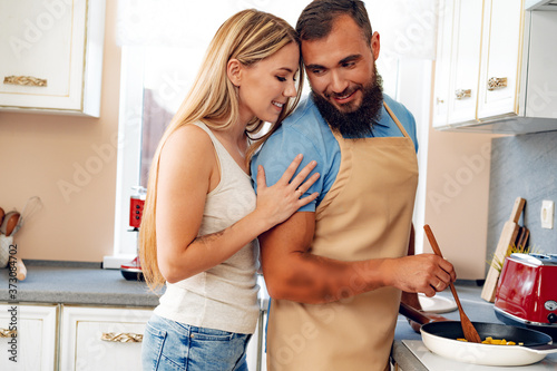 Young loving couple cooking together in kitchen