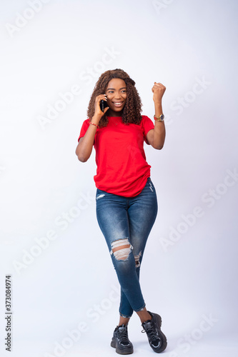young black lady making a phone call, feeling excited and happy