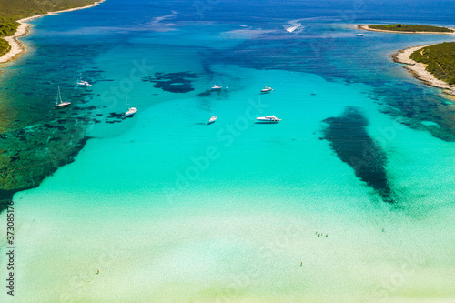 Amazing coastline in Croatia. Turquoise lagoon on Sakarun beach on Dugi Otok island, yachts and sailboats anchored in blue sea. Adriatic paradise. Drone aerial.