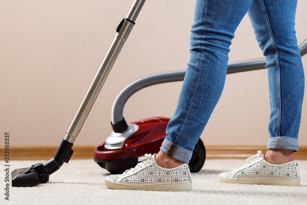 Fototapeta premium Close up of a woman vacuum-cleaning the carpet