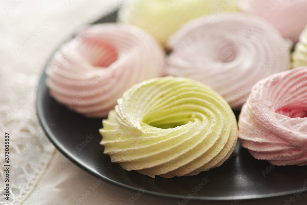 Fresh meringue rings on black plate Fresh meringue rings on black plate