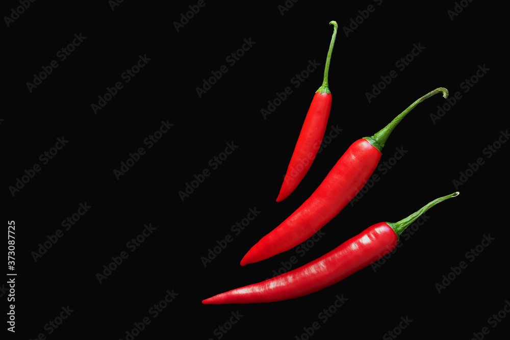 Red chili peppers on a completely black background