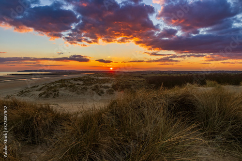 The sun setting over the high weald of east Sussex from the dunes of Camber Sands one beautiful March evening.