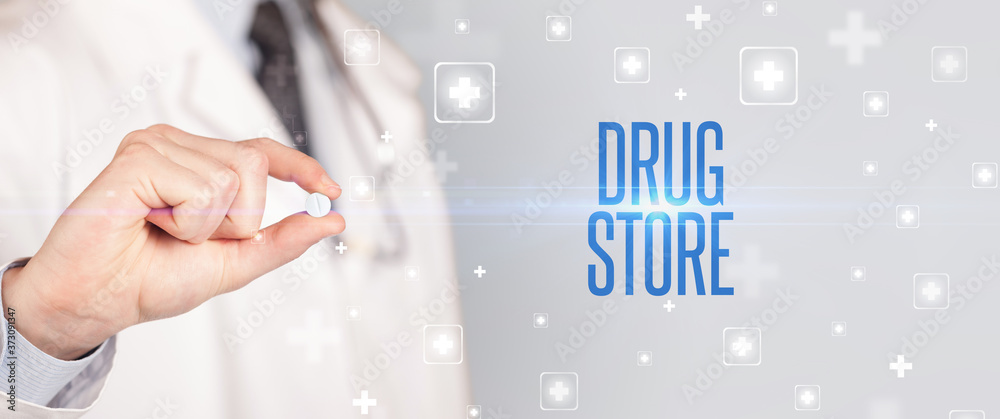 Close-up of a doctor giving a pill with DRUG STORE inscription, medical concept Close-up of a doctor giving a pill with DRUG STORE inscription, medical concept