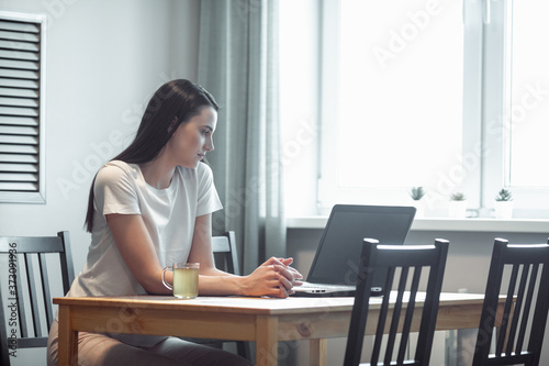 Girl working on computer laptop in light room