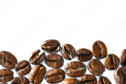 Roasted coffee beans on white milk background. Coffee beans in milk. Top view macro shot of arabica, robusta and iberica coffee seeds. 