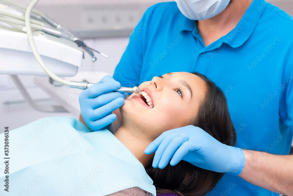 Fototapeta premium Attractive young woman in a dental clinic with a male dentist. Healthy teeth concept.