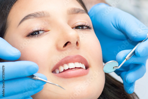 Fototapeta Naklejka Na Ścianę i Meble -  Teeth health concept. Cropped photo of smiling woman mouth under treatment at dental clinic
